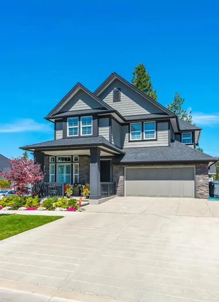 New concrete driveway leading to a two-story home