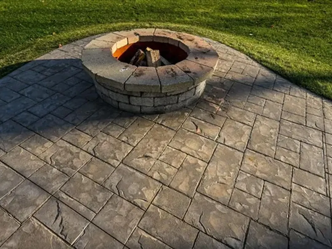 Stamped concrete patio around a stone fire pit