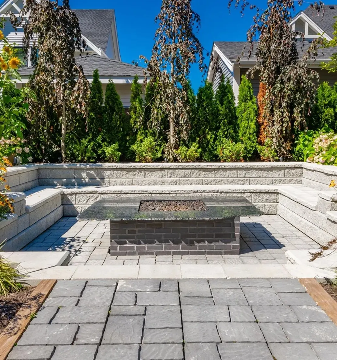 Sunken stone patio with a built-in fire table